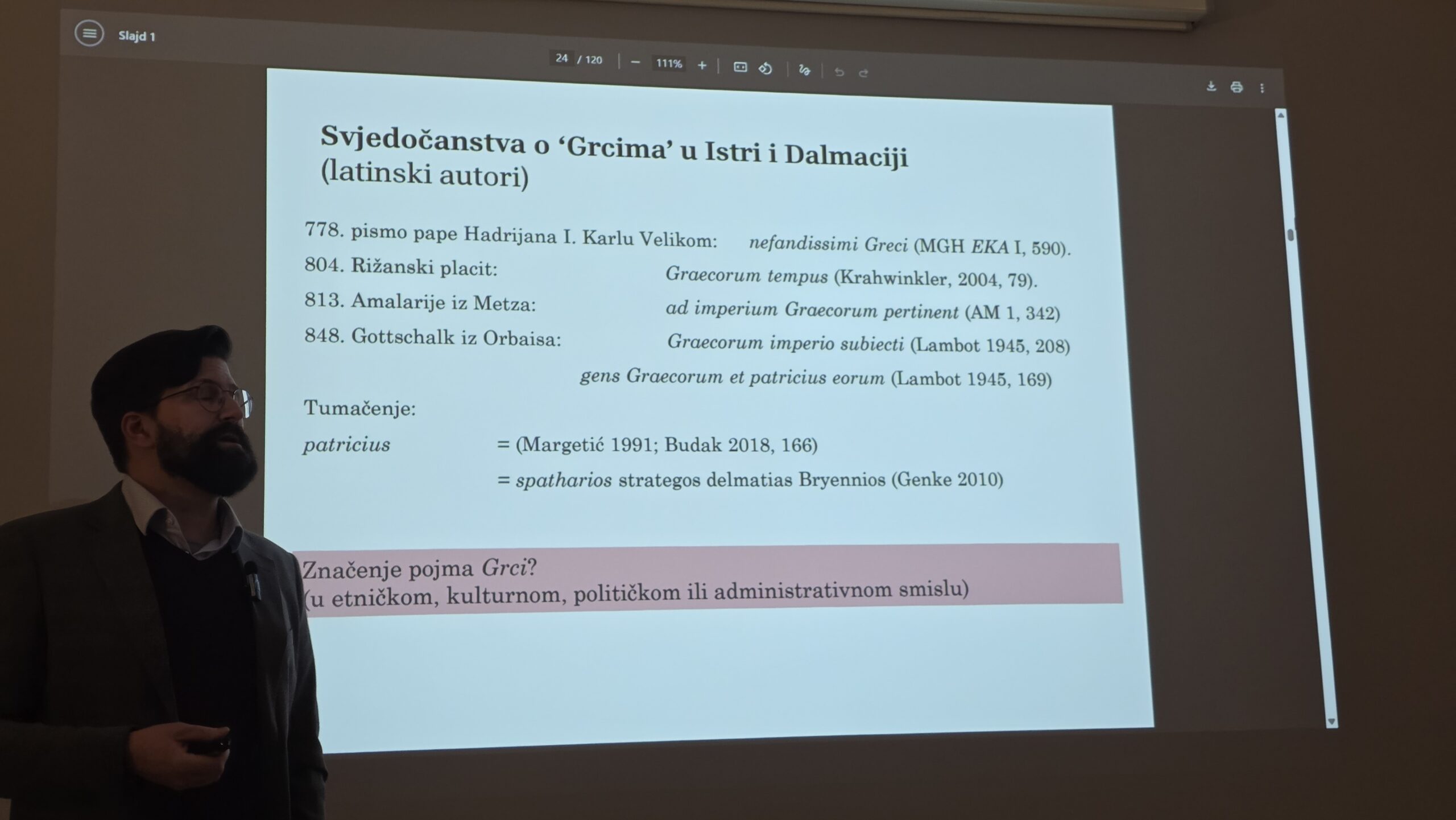 Dr. sc. Trpimir Vedriš tijekom predavanja „Hrvati, Franci i Bizant: novi pogled na početke hrvatske državnosti“, održanog u siječnju 2026. u sklopu ciklusa Predavanja srijedom tijekom izložbe U početku bijaše kraljevstvo. Na prikazanom slajdu analiziraju se srednjovjekovna svjedočanstva o „Grcima“ u Istri i Dalmaciji te njihova povezanost s bizantskom upravom na istočnom Jadranu. Foto: Blaga & misterije