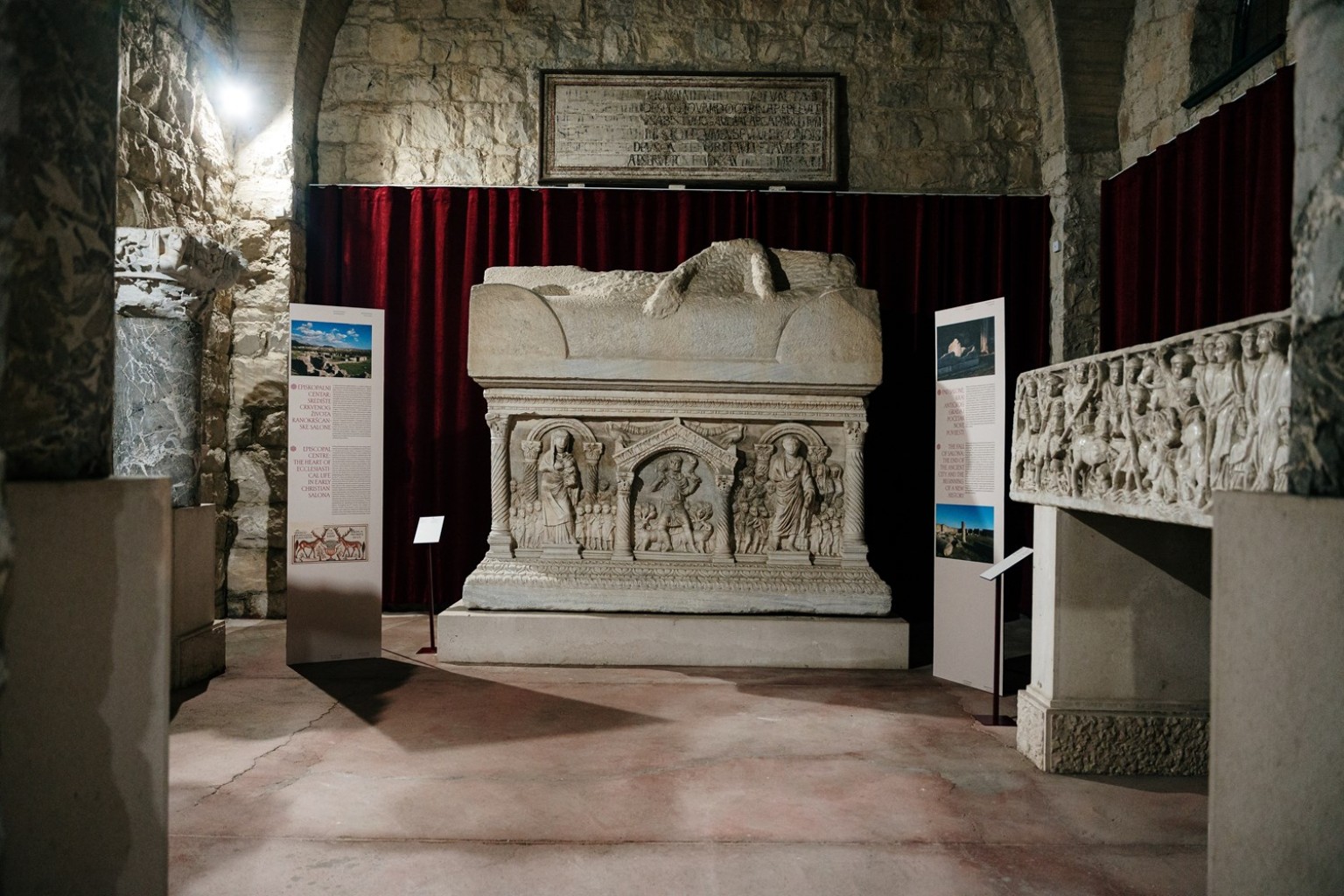 Postav izložbe „Ecclesia et Regnum“ u kojem je, desno, izložen ranokršćanski sarkofag s prikazom Prelaska preko Crvenoga mora. Predmet se danas povezuje s pitanjem njegove izgubljene srednjovjekovne biografije i mogućega puta između Salone, Solina i Splita. FOTO: Frano Bilić