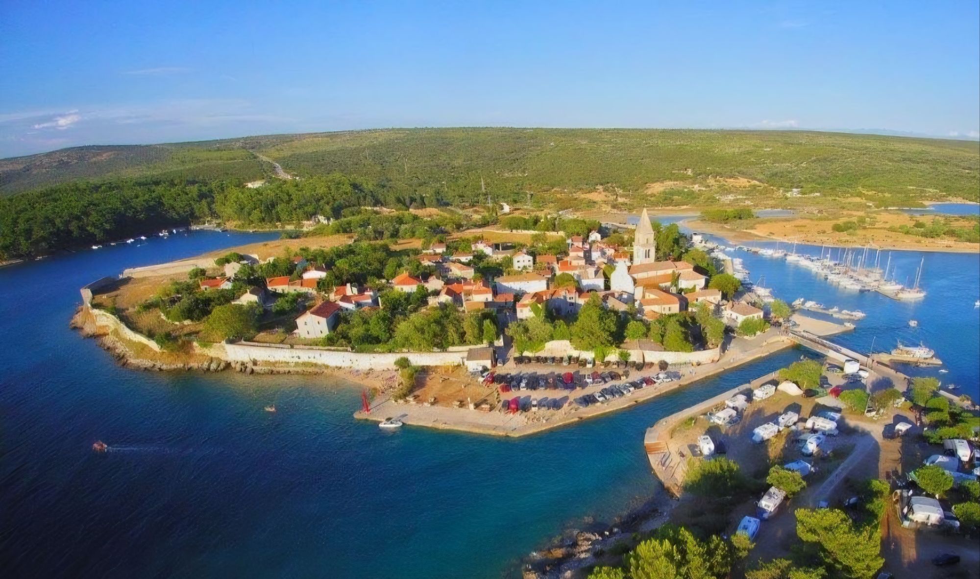 Zračni pogled na Osor, na kojem se jasno iščitava linija nekadašnjih gradskih zidina i kompaktna struktura povijesne jezgre. Foto: Turistička zajednica Grada Cresa.